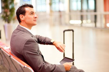 Businessman checking time at airport clipart