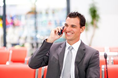 Happy businessman talking on cell phone clipart