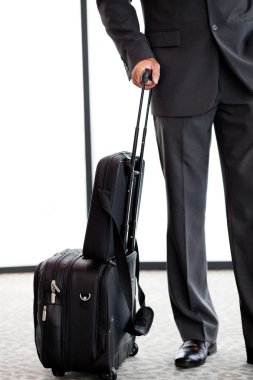 Businessman with luggage at airport clipart
