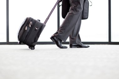 Businessman walking in airport clipart