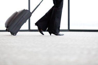 Businesswoman walking in airport clipart