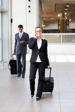 Businesspeople walking in airport clipart