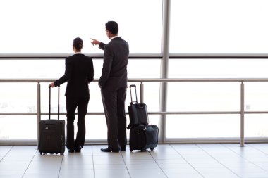 Silhouette of two businesspeople at airport clipart