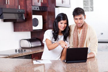 Young indian couple using computer clipart