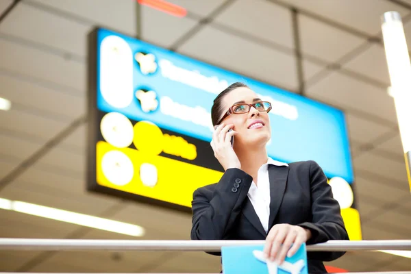 Affärskvinna som talar i mobiltelefon på flygplats — Stockfoto