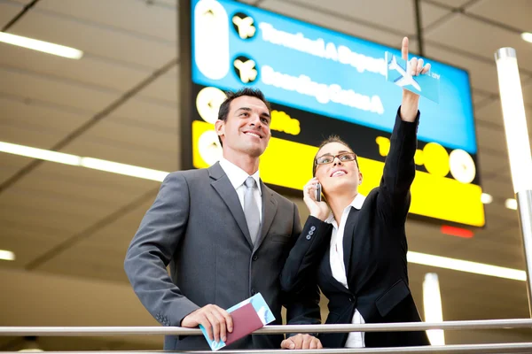 Business travellers checking boarding information — Stock Photo, Image