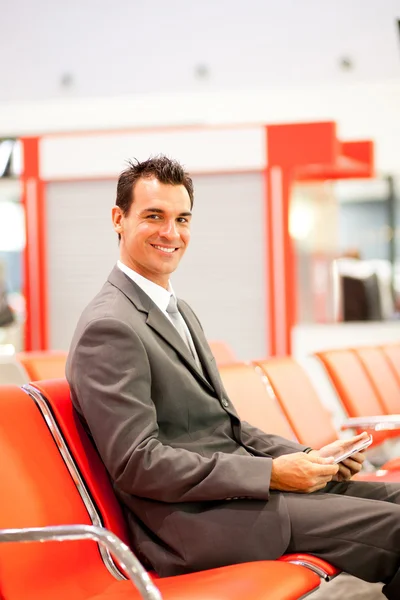 Щасливий бізнесмен, використовуючи планшет в аеропорту — стокове фото