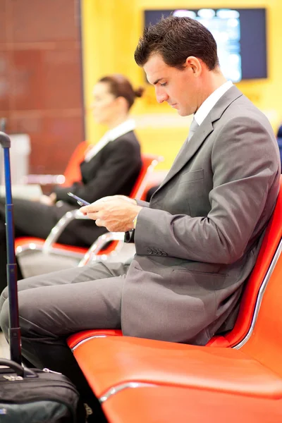 Επιχειρηματίας, αποστολή μηνυμάτων κειμένου στο αεροδρόμιο — Φωτογραφία Αρχείου