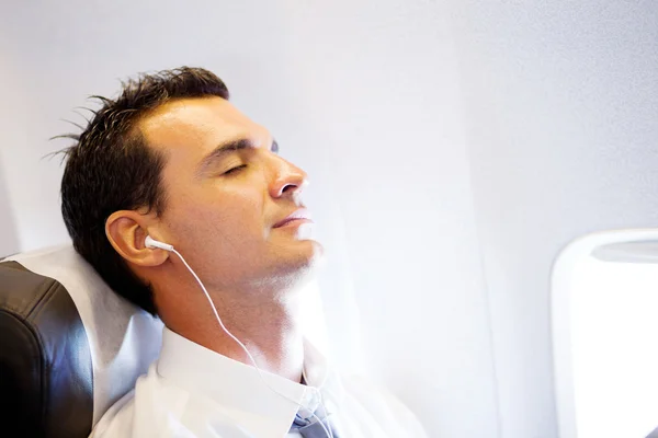 Homem de negócios cansado relaxando no avião — Fotografia de Stock
