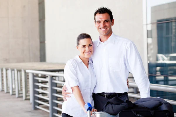 Happy couple pushing trolley at airport — Stock Photo, Image
