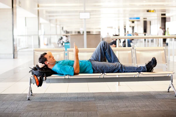 Молодой человек отдыхает в аэропорту — стоковое фото