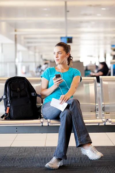 Jonge vrouw wacht op haar vlucht — Stockfoto