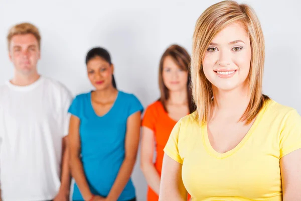 Teen girl standing in front of group — Stock Photo, Image