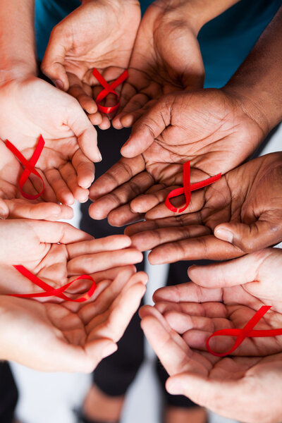 Group of multiracial holding red ribbon with both hands