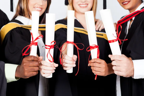 Group of graduates holding certificates — Stock Photo, Image