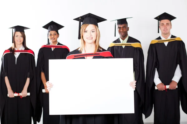 Muito feminino graduado segurando placa branca — Fotografia de Stock