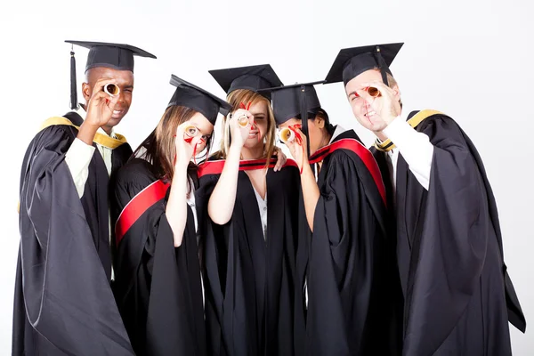 Grupo de graduados mirando a través de su diploma —  Fotos de Stock