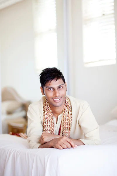 Young indian man lying on bed — Stock Photo, Image