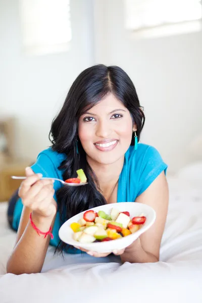 Cheerful young woman eating fruit salad — Stock Photo, Image