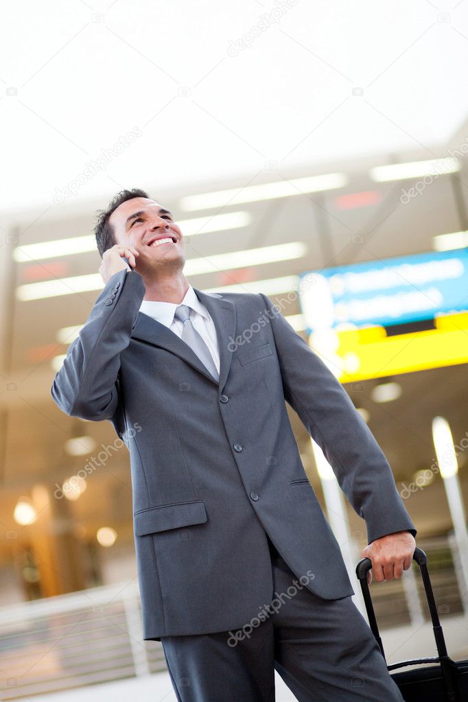 Businessman talking on cellphone at airport