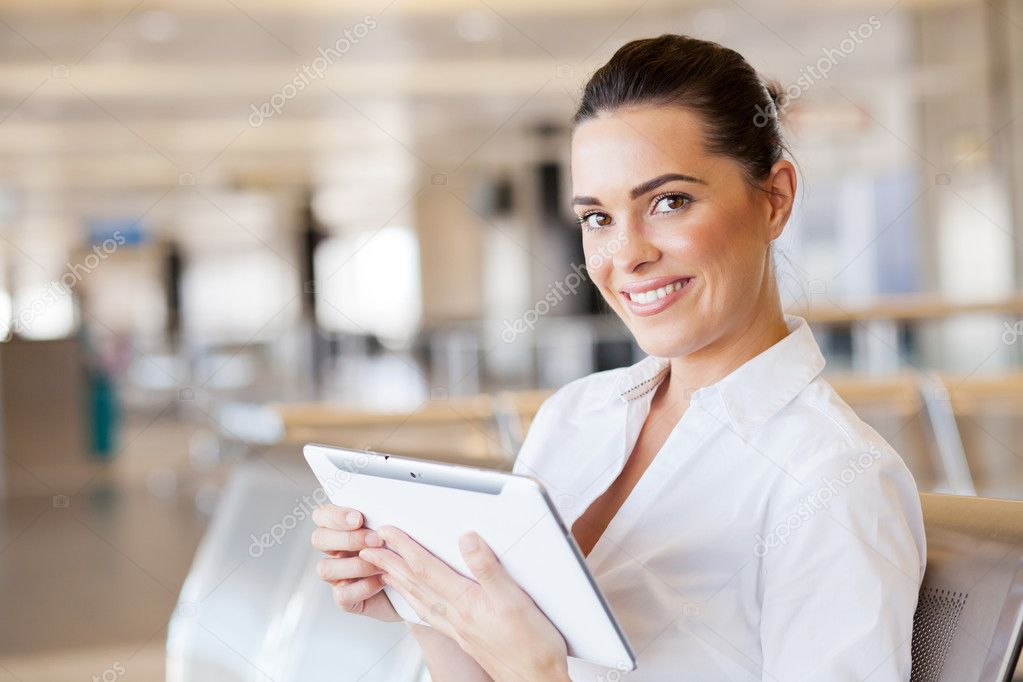 Young woman using tablet computer at airport