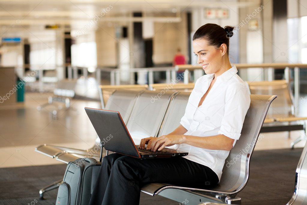 Young woman using laptop computer at airport