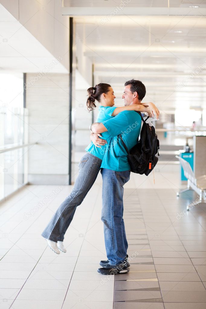 Happy young couple hugging at airport