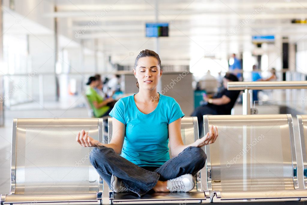 Young woman doing yoga meditation at airport