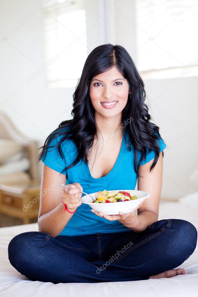 Young woman eating fruit salad