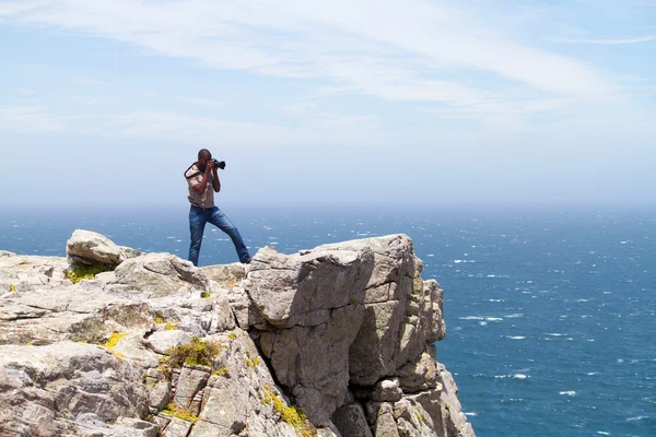 Photographer taking photos on cliff — Stock Photo, Image