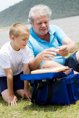 Grandfather and grandson fishing clipart