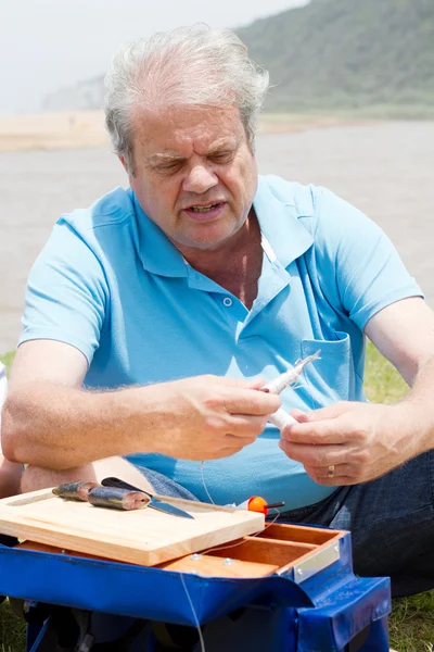 Senior homme mettre appât sur crochet de pêche — Photo