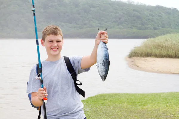 Teen chlapec ukazuje ryba, kterou chytil — Stock fotografie