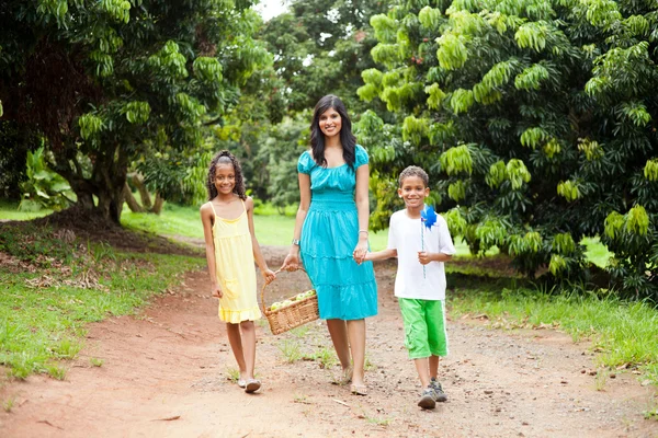 Stock image Mother and kids walking in fruit garden