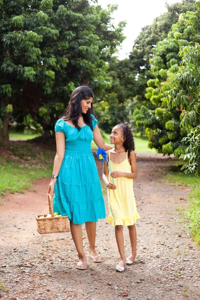 Moeder en dochter wandelen in vrucht tuin — Stockfoto