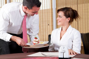 Waiter brings to the customer the ordered dessert clipart