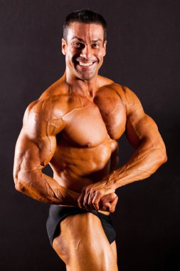 Bodybuilder on black background clipart