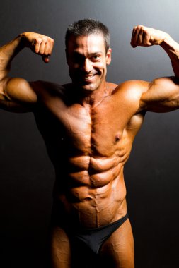 Bodybuilder on black background clipart