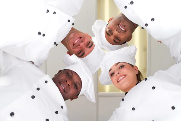 Group of professional chefs heads together form a team — Stock Photo, Image