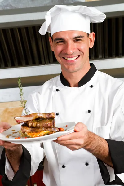 Jovem chef masculino apresentando comida — Fotografia de Stock