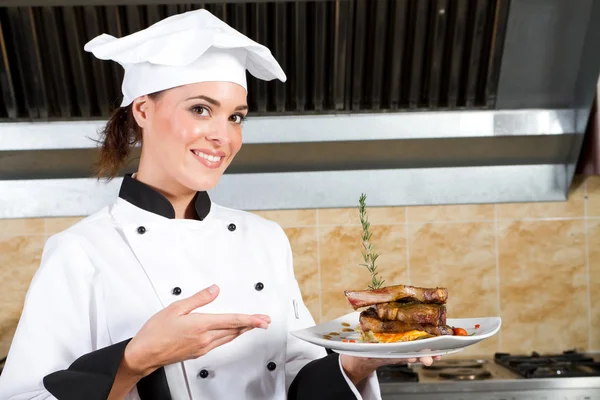 Jovem chef feminino bonito apresentando comida — Fotografia de Stock