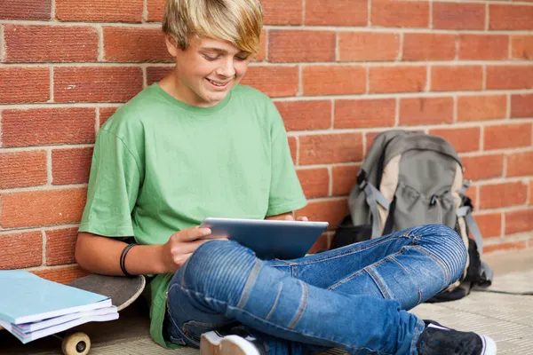 십 대 소년 학교에 태블릿 컴퓨터를 사용 하 여 — 스톡 사진