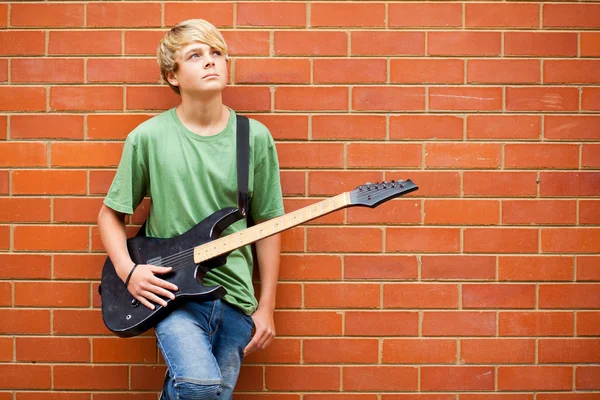 Teenie-Junge mit Gitarre tagträumt — Stockfoto