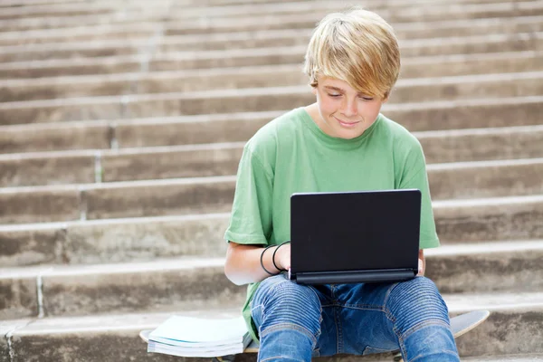 Хлопчик-підліток використовує ноутбук на відкритому повітрі — стокове фото