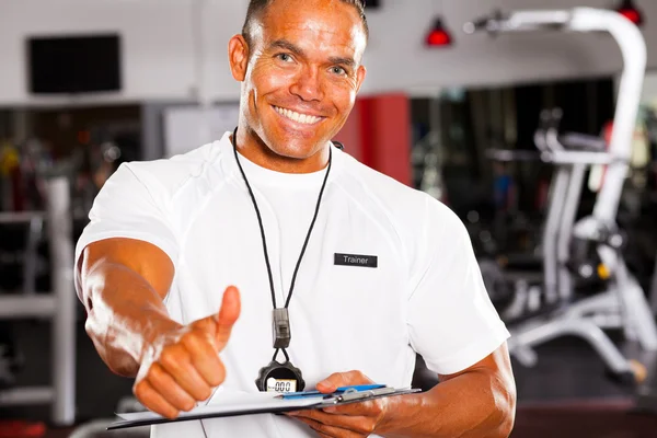 Male gym trainer giving thumb up — Stock Photo, Image