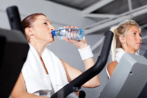 Mulher bebendo água durante o exercício no ginásio — Fotografia de Stock
