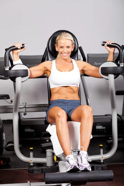 Mulher fitness usando máquina de plataforma peck — Fotografia de Stock