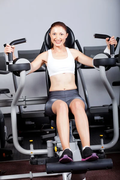 Fitness woman exercising with peck deck machine — Stock Photo, Image