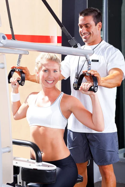 帮助客户端在健身房中的私人教练 — 图库照片