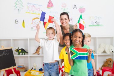 Preschool kids and teacher with flags in classroom clipart